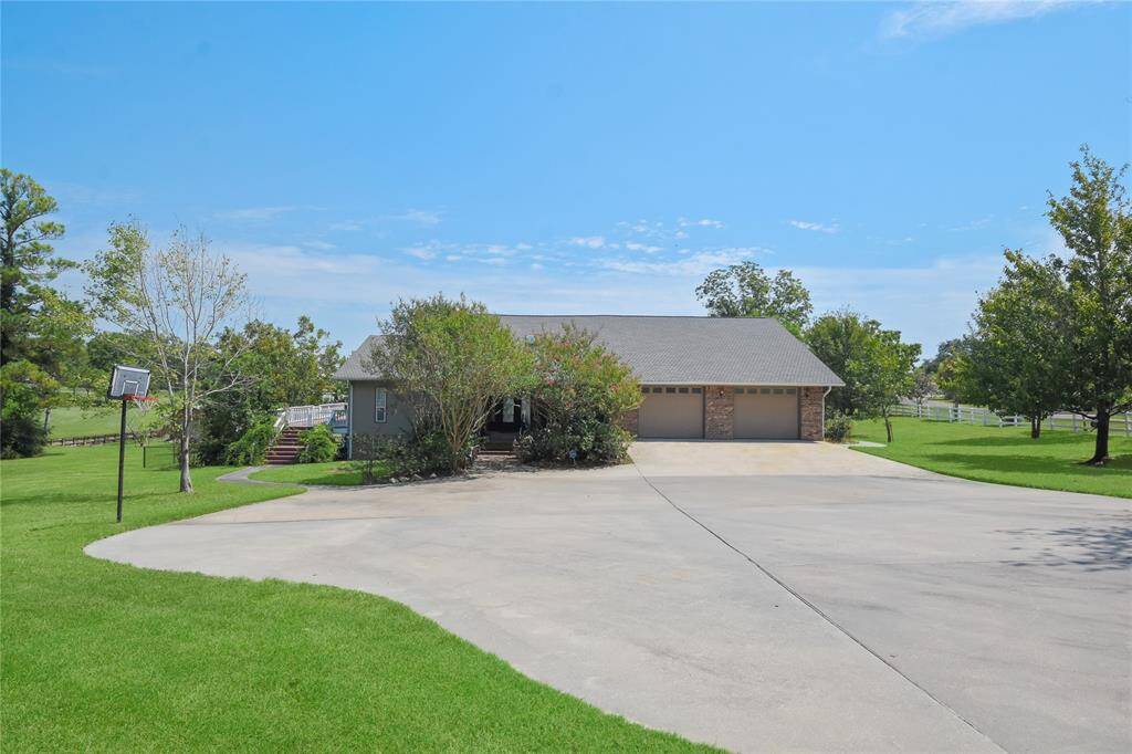 After entering into the front gate, here again is the very oversized parking pad area at the front of the home. The split-level home is two levels. The primary level is actually the second level, which is where you enter. Much of the extra bedrooms and casual living space is downstairs.
