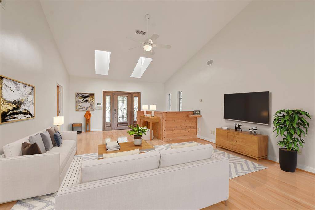 A last look at the spacious and comfortable living area, shown here virtually staged.  There is plenty of wall space for art, flat screen TV's, etc..... This perspective looking back at the front door.  The stairway down to the lower level is just to right of the front door here.  The doorway at rear left leads to the guest half bath.