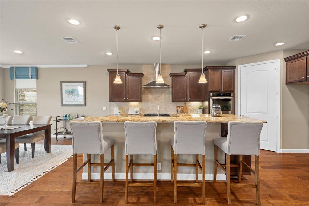 The high bar offers additional seating, making it a focal point for gatherings & meal preparation.