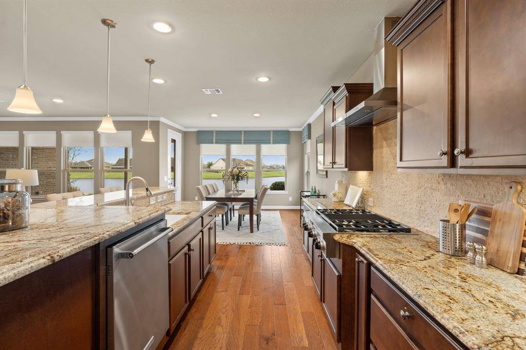 This exceptional kitchen has upgrades/options that were only available in homes built 2015 or later, is truly one of a kind! Thoughtfully designed with a spice rack on either side of the 6-burner gas cooktop, deep drawers for pots and pans, and an elevated dishwasher for effortless loading. The KitchenAid double oven offers versatile cooking options, including Bake, Convection, Roast, Broil, and Bread Proofing. A rare find in Del Webb—don’t miss this opportunity!