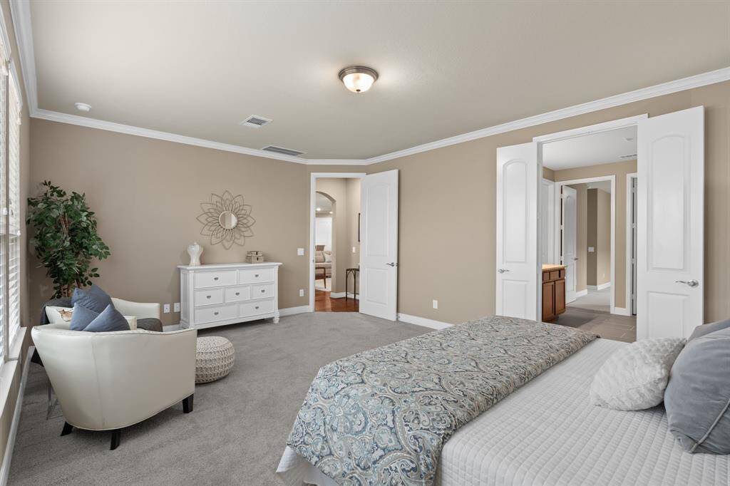 Step through the 8-foot double doors into your en-suite bath, where elegance meets comfort. The owner's suite is beautifully accented with crown molding and a sophisticated two-tone paint, adding a touch of luxury to this serene space.