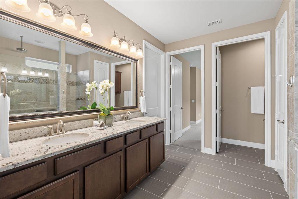 A plethora of upgrades make this en-suite bath truly exceptional. From the framed mirrors and upgraded flooring to the luxurious spa shower and high-end granite, every detail has been thoughtfully designed. It’s the perfect retreat for a relaxing shower after a day of pickleball, offering the ultimate in comfort and style.