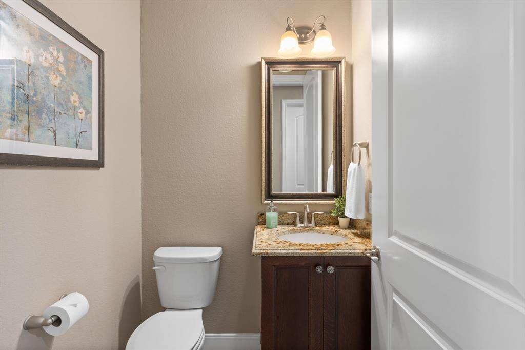 Step into the half bath and discover a space that exudes charm and character. The framed mirror and high-level granite adds a touch of artistic flair that instantly captures your attention. The cabinet adds some nice storage options.
