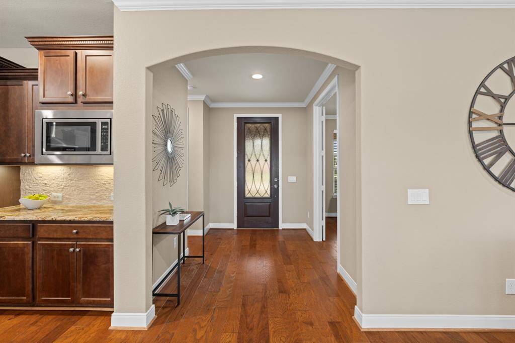 Looking back, the upgraded 8-foot front door stands as a striking focal point. Its elegant glass design invites natural light to pour into the entry, creating a bright and welcoming ambiance.