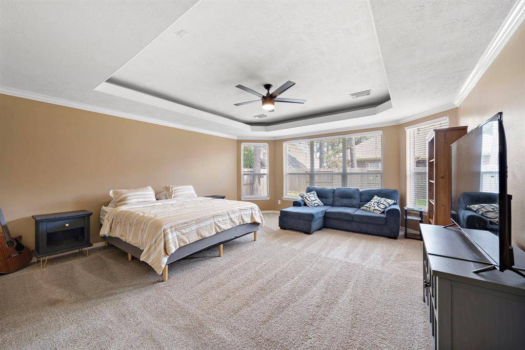 Relax in the serene primary bedroom, bathed in natural light with space for a cozy reading corner, and elegant tray ceilings.