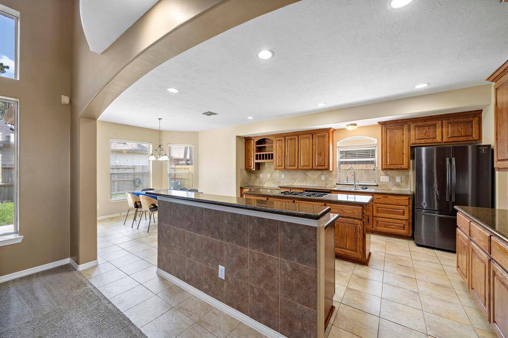Cook in style with a stunning kitchen featuring a generous island, a sleek dry bar, and ample cabinet space for all your culinary needs.