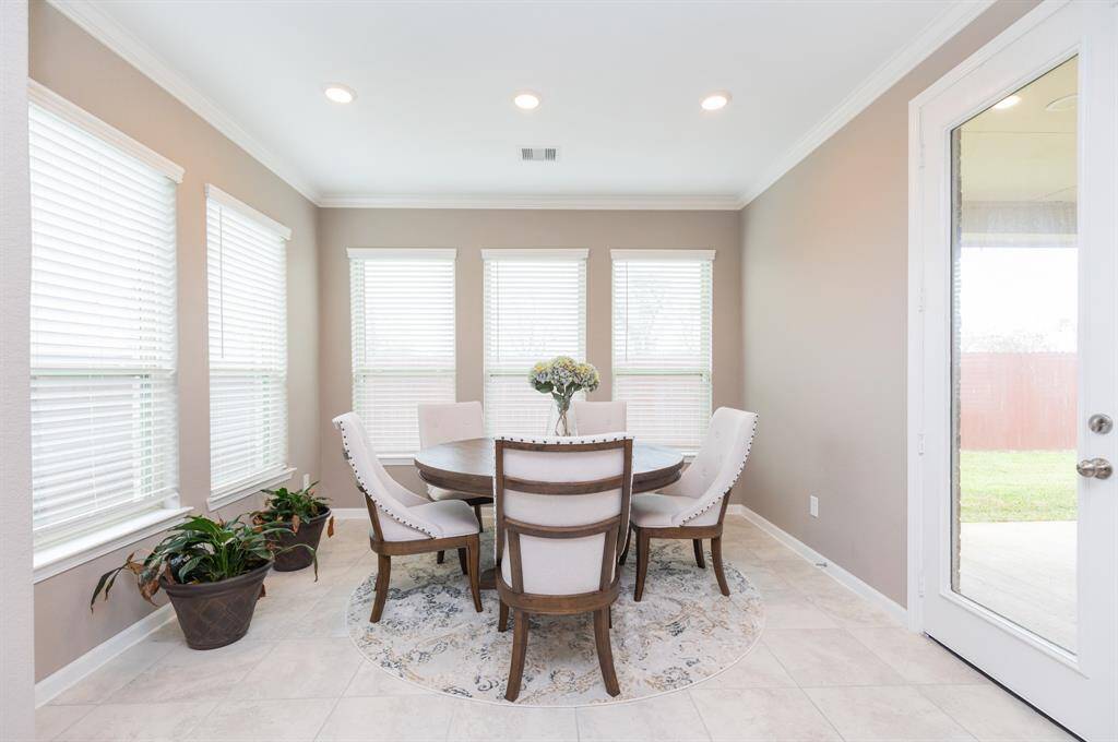 inviting breakfast room boasts large windows that flood the space with natural light.