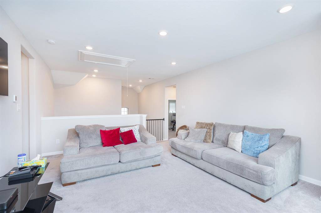 spacious 2nd living area with recessed lighting creating a welcoming space for relaxation or entertainment.