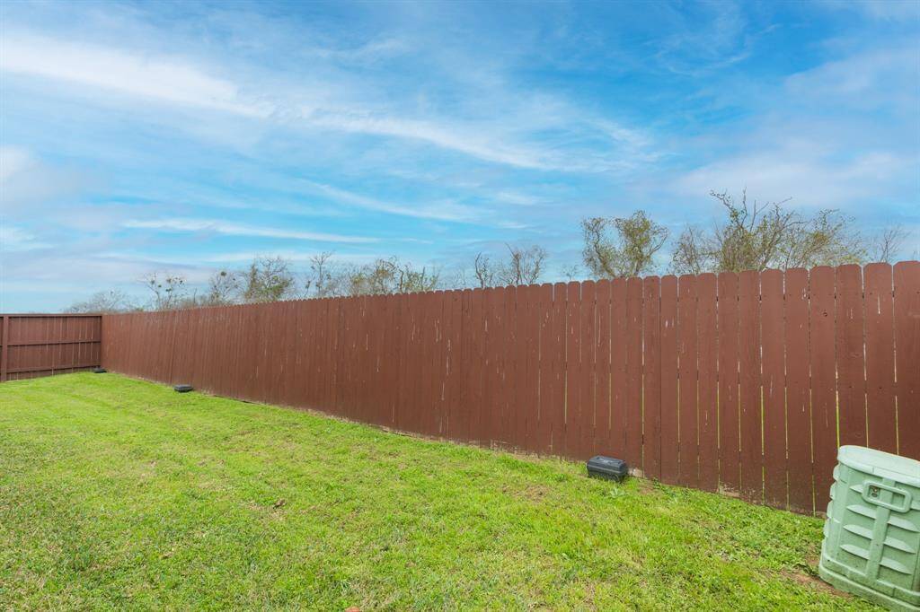well-maintained green lawn wooden privacy fence.