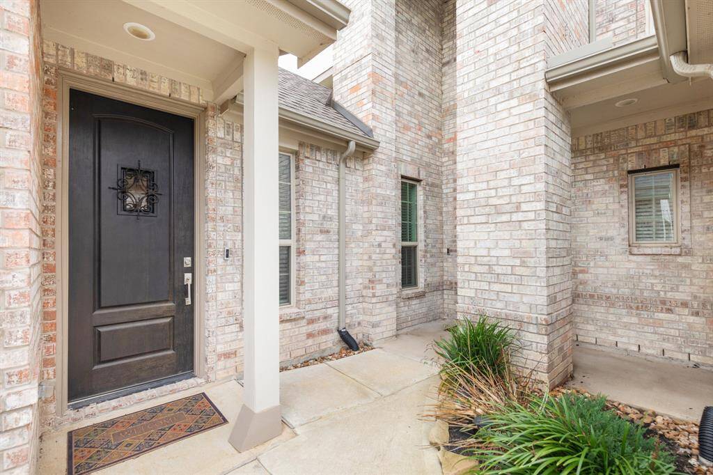 inviting entryway complemented by a neatly trimmed garden offering a warm welcome to the home.
