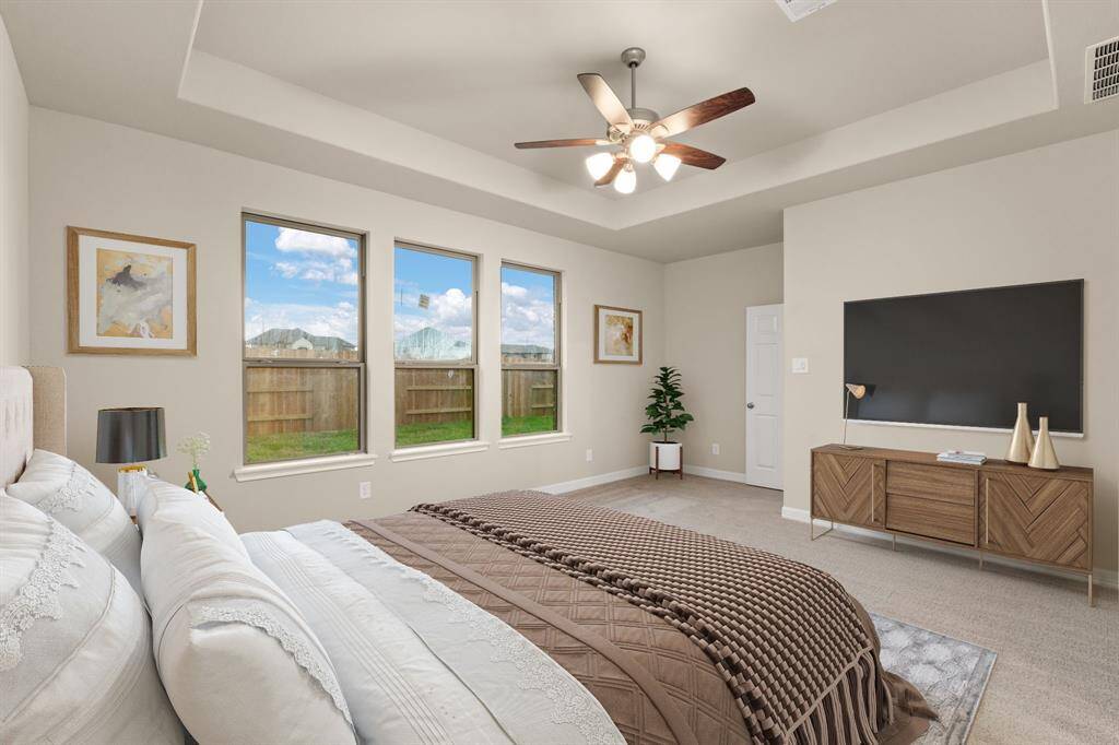 The primary bedroom is generously sized, creating a tranquil and spacious retreat that offers ample room for relaxation. Featuring plush carpet, high ceilings, fresh paint, and large windows that lets in natural lighting throughout the day. Photo is virtually staged