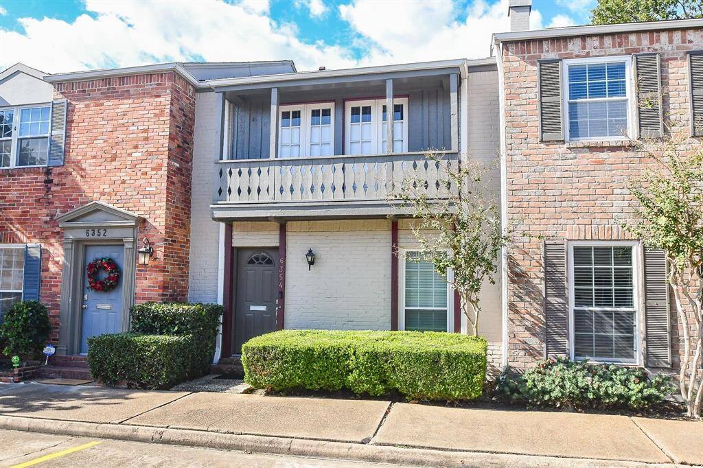Charming two-story townhouse with a classic brick facade and a quaint balcony. Features include a neatly trimmed front hedge, a private entrance, and a small front porch. Ideal for those seeking a cozy, low-maintenance home in a well-maintained neighborhood.