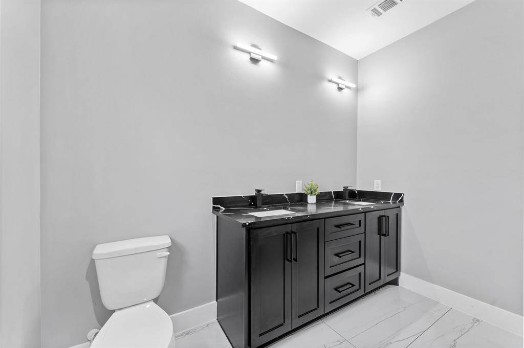 Luxurious primary bath with double sinks, stylish countertops, and modern fixtures.