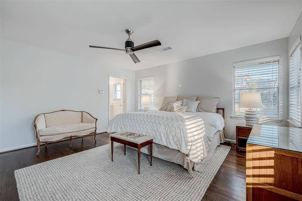 The primary bedroom is large with lots of windows facing the back and side of the home.  It has beautiful wood floors and a ceiling fan.