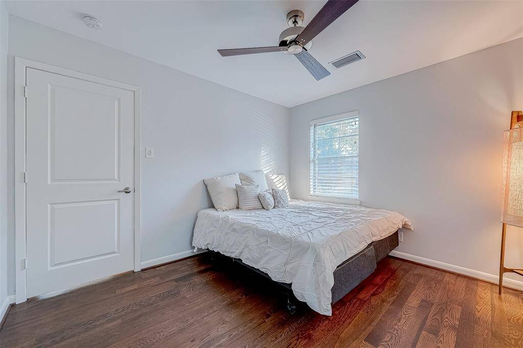 Another secondary bedroom with wood floors and a ceiling fan.