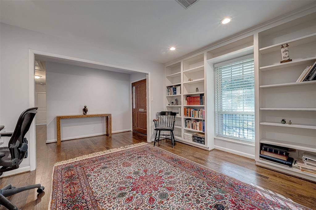 The opposite wall shows a window to the front porch and three built in book shelves.