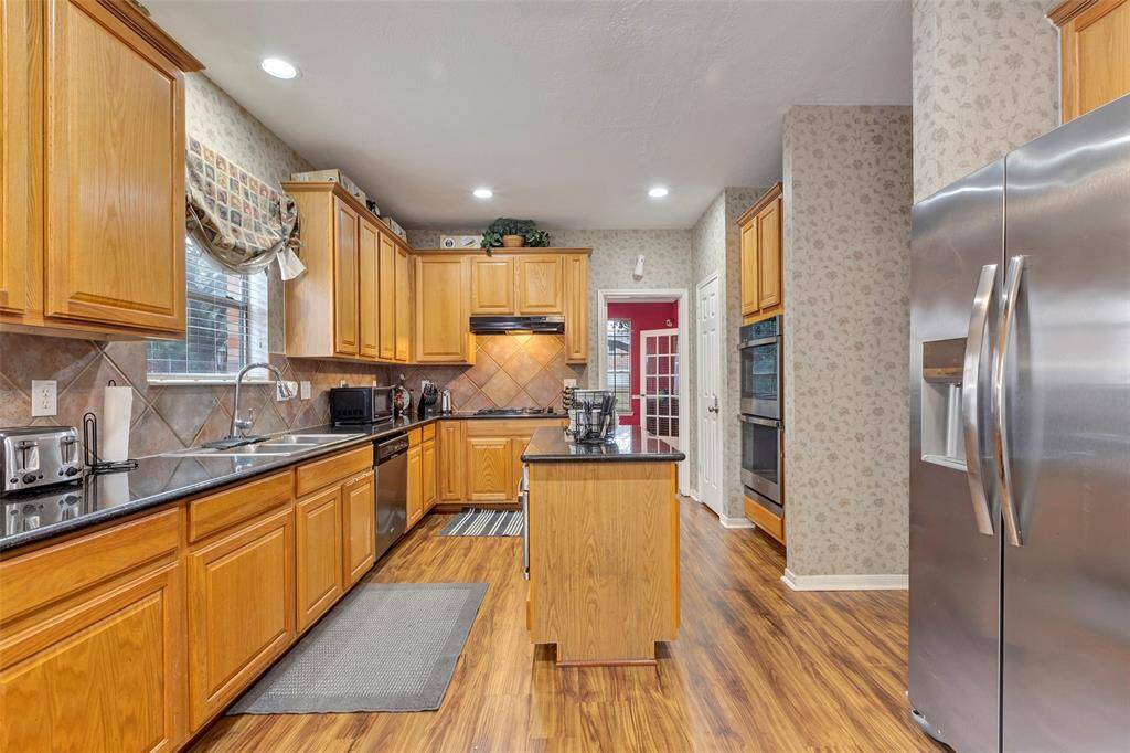 Island without stove. Deep stainless sink with window. Granite counters. Stainless appliances. Wood like floors added 2023.