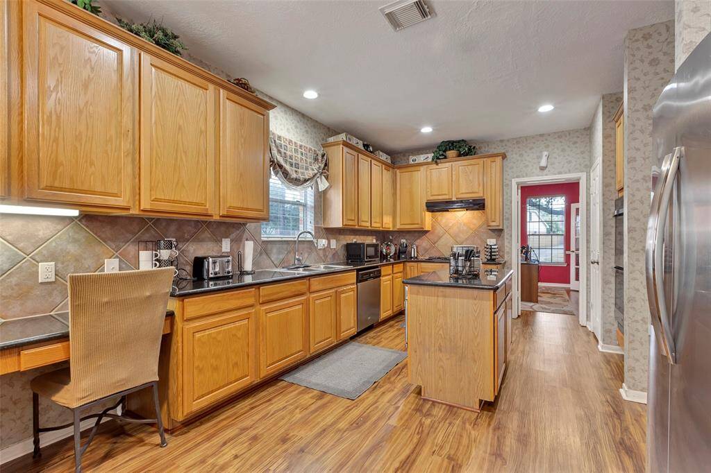 Tile backsplash in the kitchen. Secretary for sitting with undermount lighting.