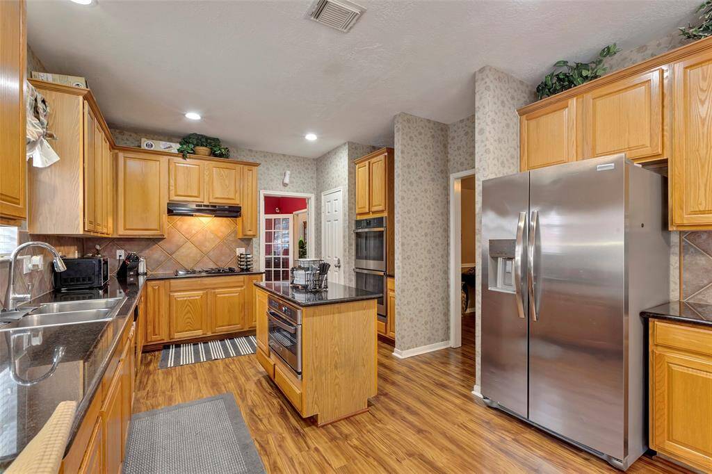 Microwave in island. Lots of cabinets for storage. GE Double ovens 2023. Walkin pantry to left of  stainless double ovens.