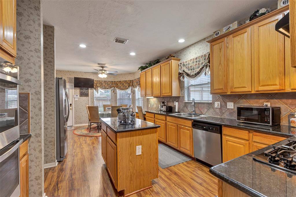 View of the breakfast room with a bay window.The kitchen has a  4 burner GE gas cooktop 2024.Dishwasher replaced 03/2025