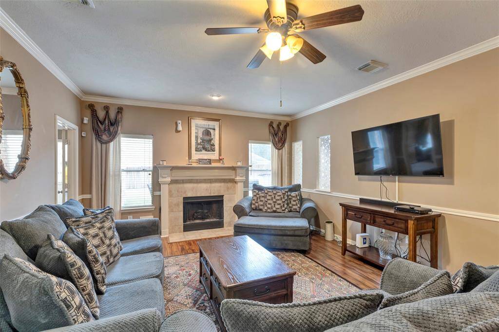 Crown molding and chair rail molding. Gas fireplace. Ceiling fan with light. Wood like floors.