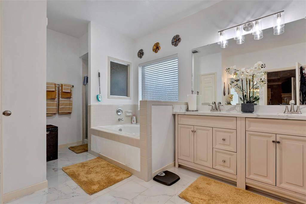 Primary bathroom has designer lights, Jetted garden tub and seperate shower. Window over garden tub.