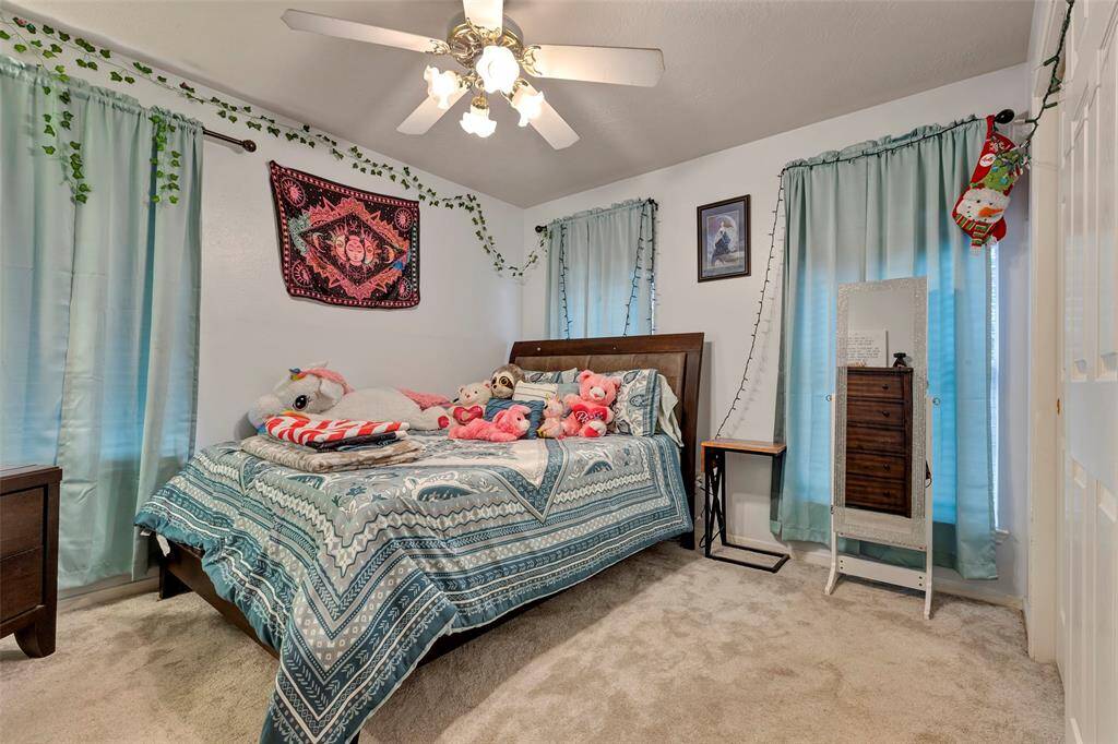 Second bedroom upstairs in the front of the home. Ceiling fan and lights.