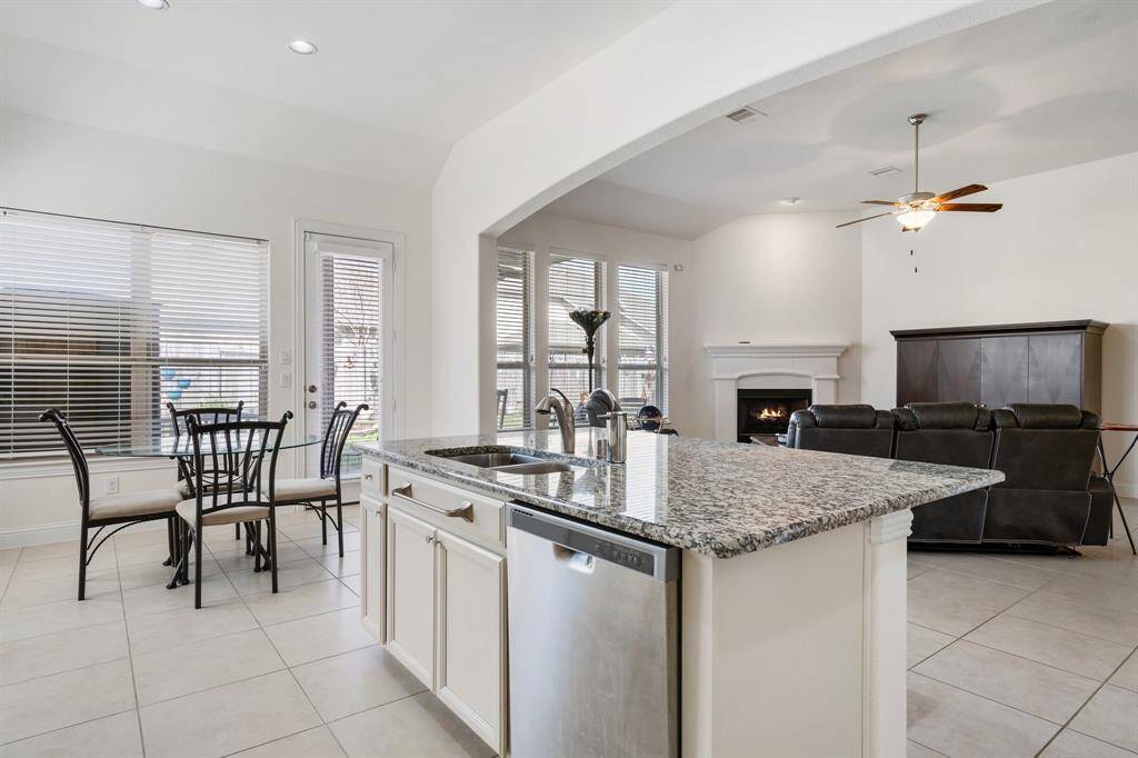 Bright and spacious living room features a cozy fireplace, large windows for natural light, and elegant tile flooring.