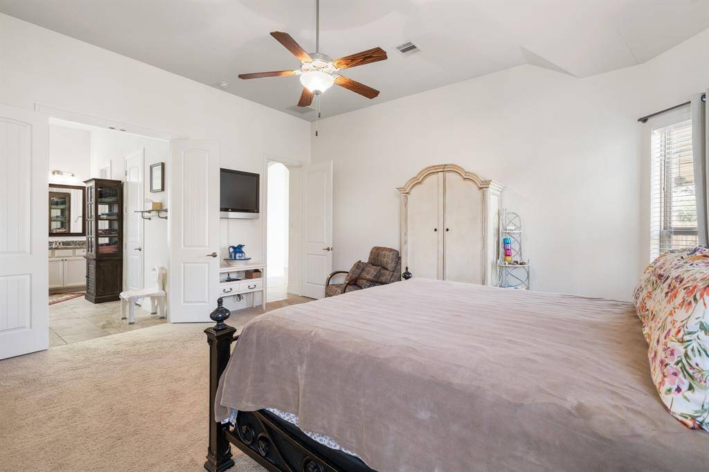 Primary bedroom includes vaulted ceilings and plush carpeting for a cozy feel.