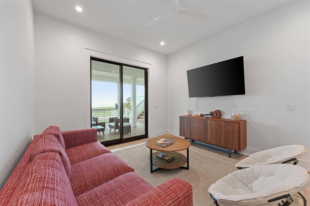 Spacious first-floor bonus living area with direct deck access, perfect for relaxing or entertaining.