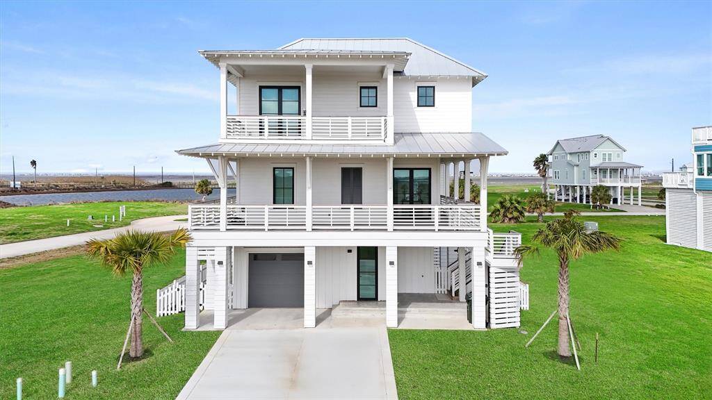 A stunning three-story coastal retreat in Sweetwater Cove, offering expansive wraparound decks and breathtaking bay views.