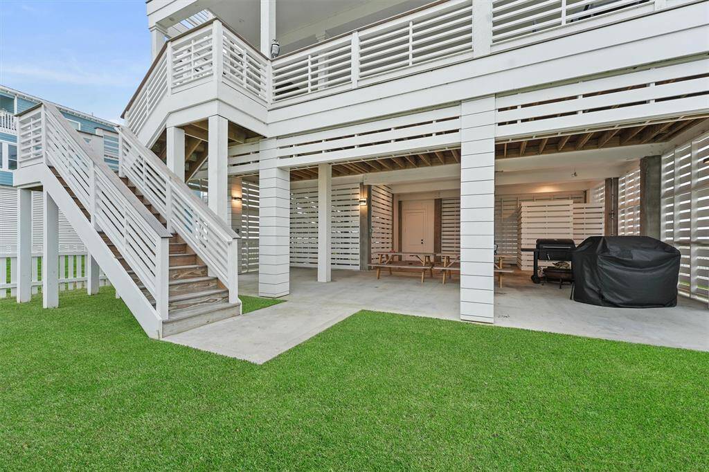 Spacious covered patio and outdoor entertaining area featuring picnic tables, a grill, and easy access to the upper deck.