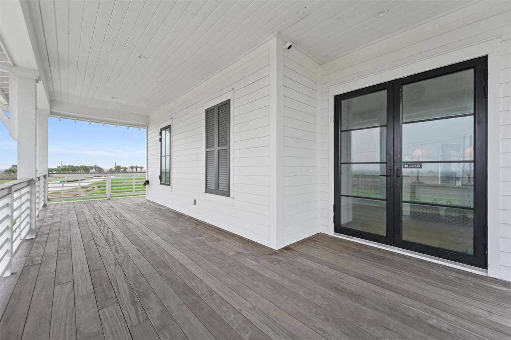 Welcoming front entry with elegant black-framed French doors, setting the tone for the home's modern coastal design.