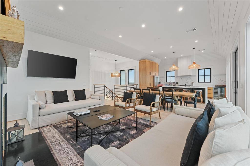 Seamless open-concept living with a cozy fireplace, stylish furnishings, and a direct flow into the dining and kitchen areas.