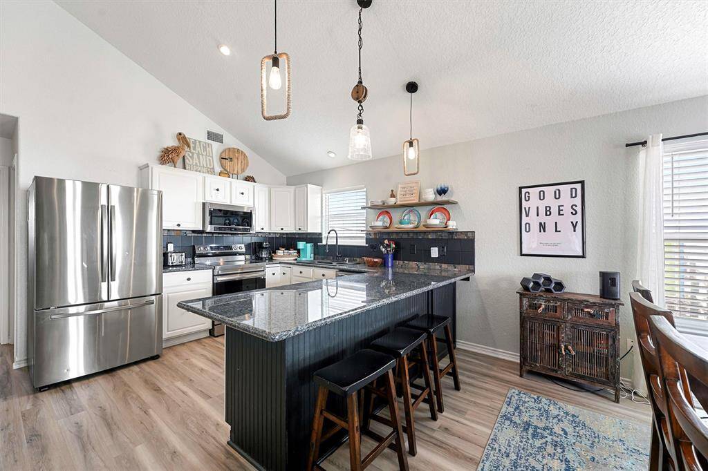 Custom lighting, granite countertops, updated appliances, pantry, vaulted ceilings, and water views.