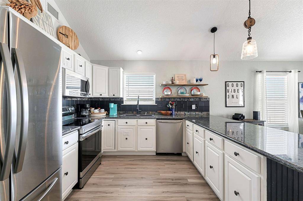 Custom lighting, granite countertops, updated appliances, pantry, vaulted ceilings, and water views.