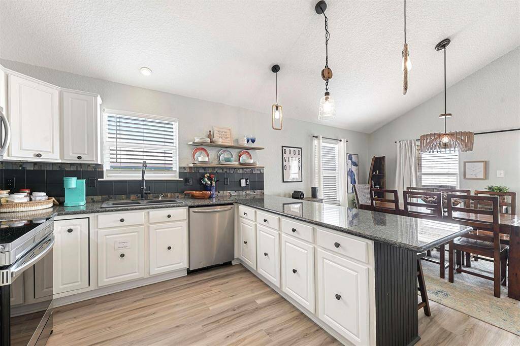 Custom lighting, granite countertops, updated appliances, pantry, vaulted ceilings, and water views.