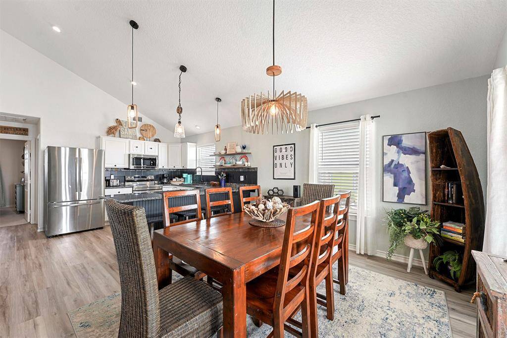 Vaulted ceilings, custom light fixture, open concept, and water views.