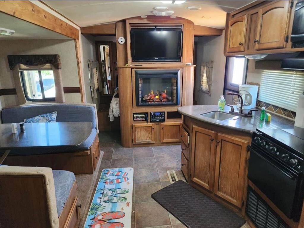Living room/kitchen with electric fireplace and flat screened tv