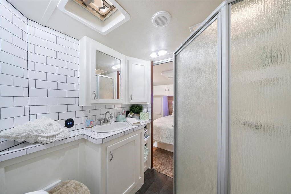 Full bathroom with walk in shower and storage