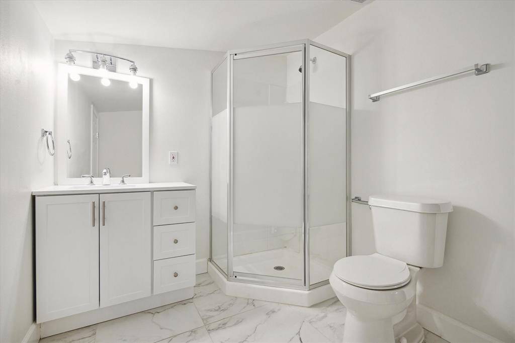 5th bedroom private bath. porcelain tiles, framed shower, LED lighting.