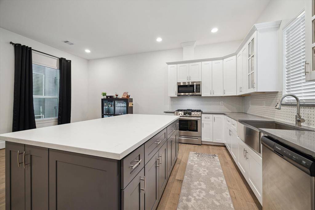 durable and classic quartz countertops, built in hide-away cabinets, SS drop in sink, 5 burner gas range, LED lighting throughout.