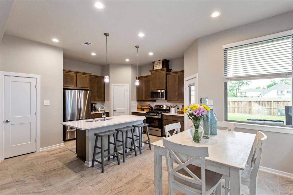 Island kitchen with quartz countertops and breakfast bar.