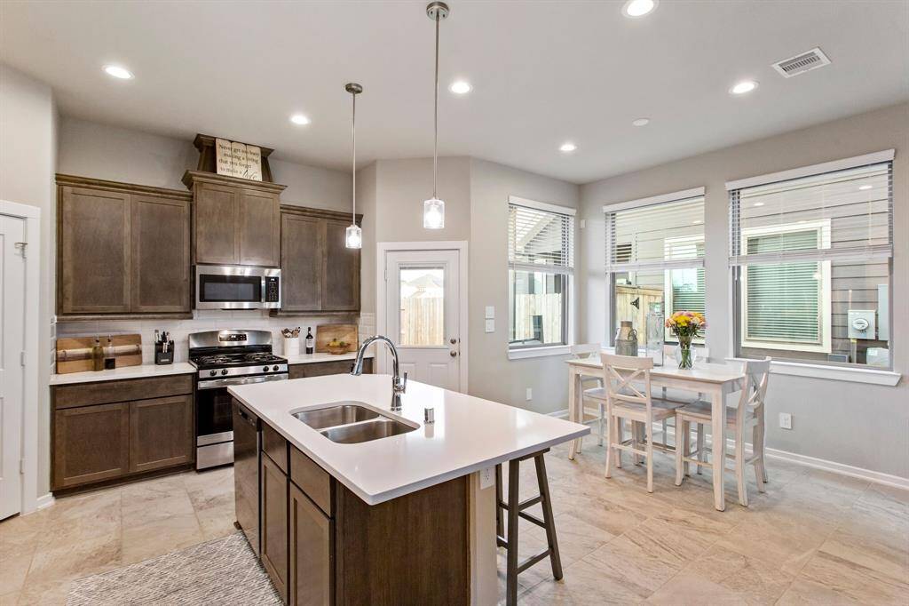 Exit the kitchen to the covered patio and large fenced backyard.