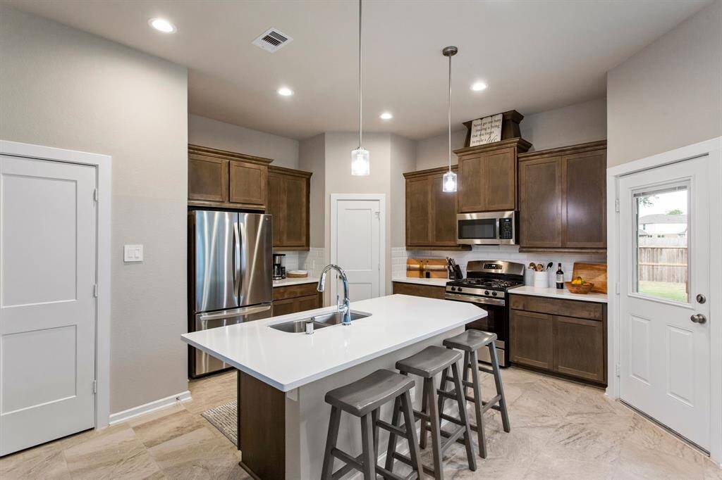 Off to the left is a half bath, for the home owners convenience.  Large walk in pantry and stainless steel appliances.