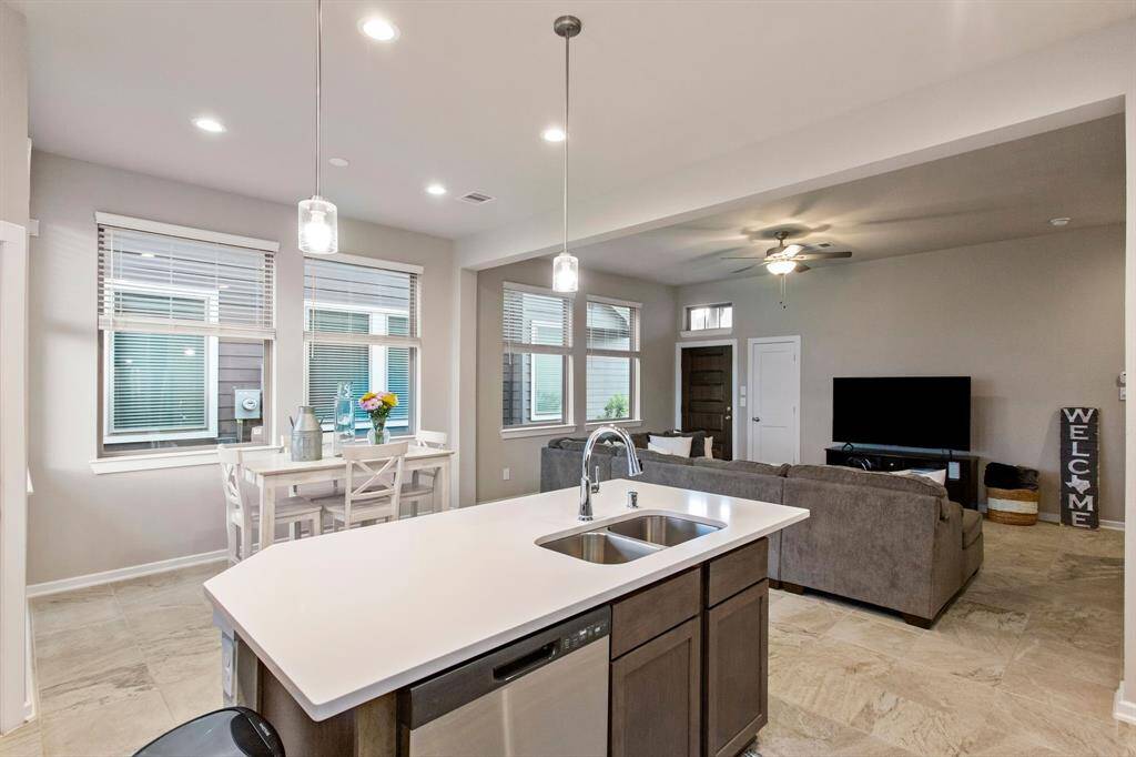 Beautiful pendant lights over the kitchen island covered in gorgeous quartz countertops.