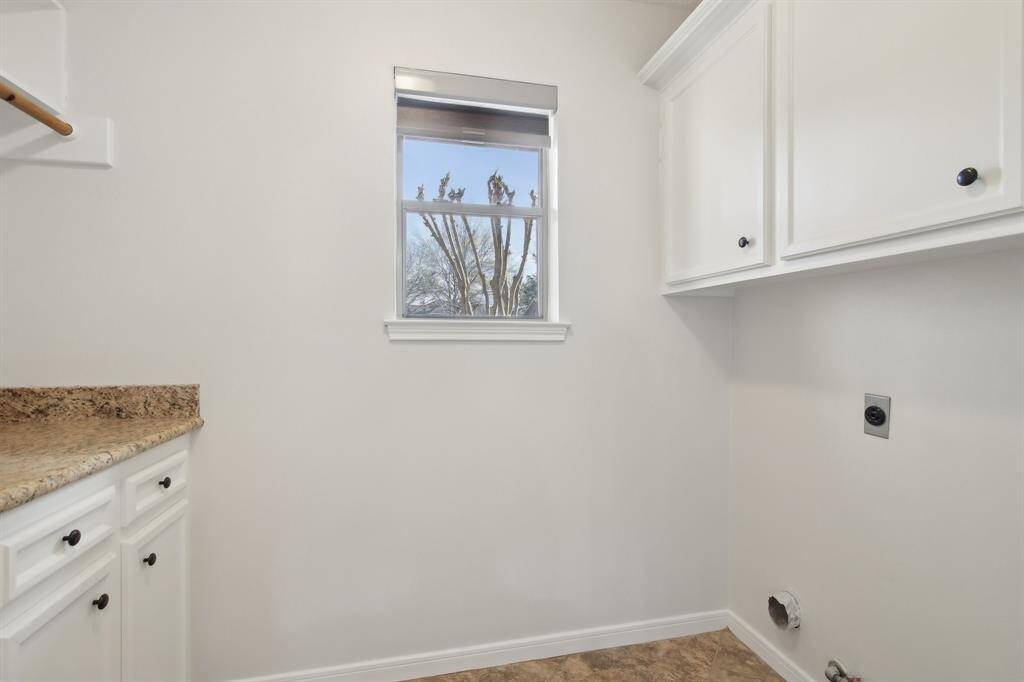 Large laundry room with cabinets and counterspace.