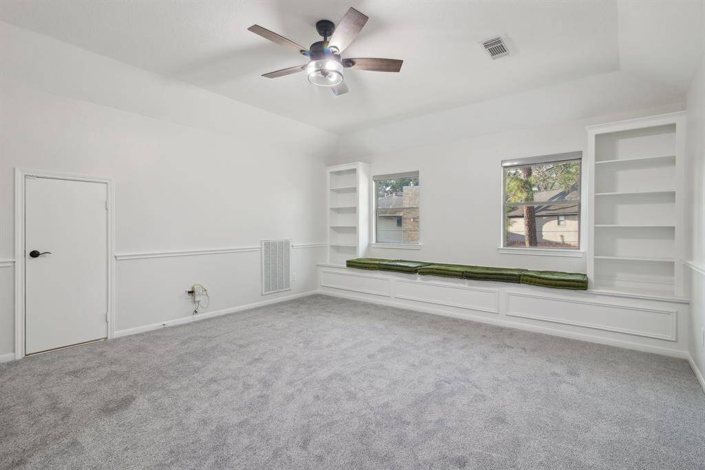 Game room at the top of the stairs with shelving and storage benches.