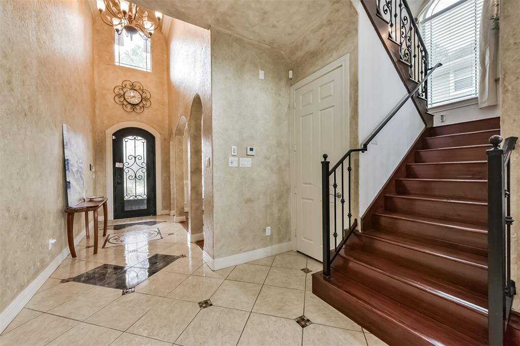 Entrance with metal door, large closet under stairs. Wood stairs.
