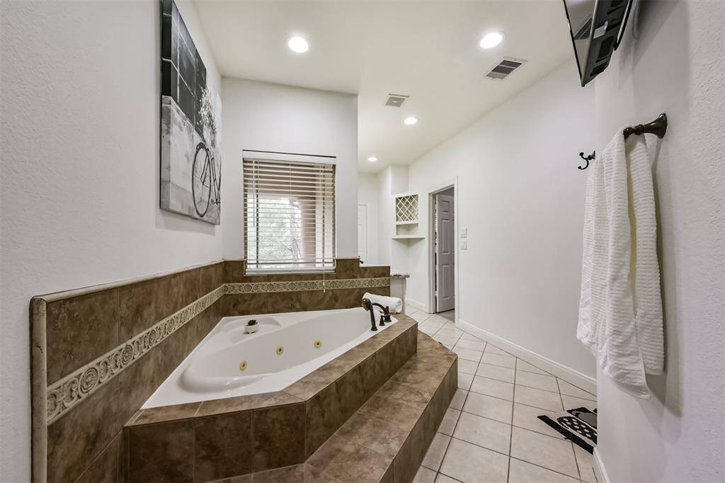 Large jetted tub with a window to let in the natural light.
